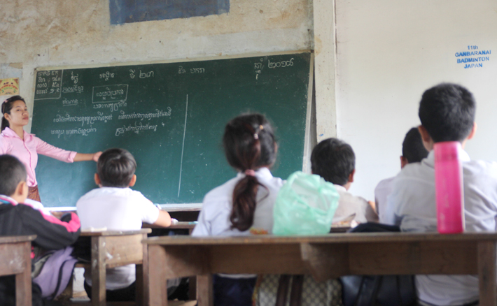 修繕された壁のある教室で授業を受ける子供たち