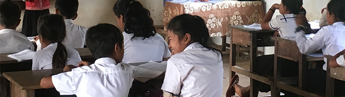 修繕された壁のある教室で授業を受ける子供たち